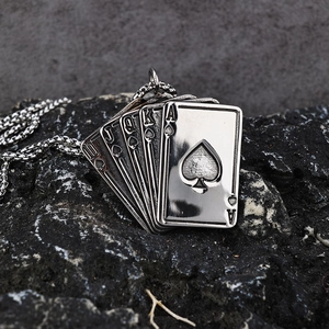 Vintage stainless steel royal flush poker pendant necklace on a dark natural rock surface