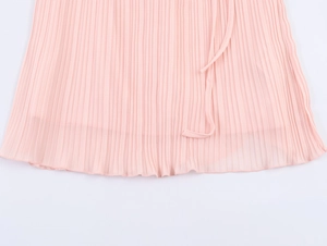 Detailed close-up of pink pleated chiffon hemline and fabric texture of the mini dress