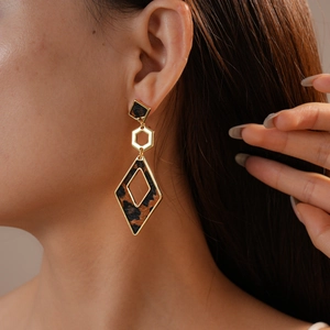 Close-up of leopard print geometric drop earrings on model for a retro autumn style