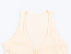 Dettaglio del collo a V e della struttura senza maniche su questo abito midi beige