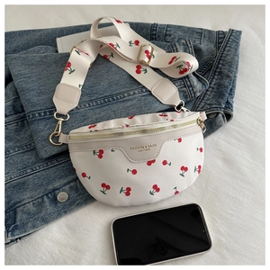 Detail of white PU leather chest bag with cherry print and golden zipper on denim jacket
