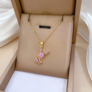 Macro shot of pink zircon rabbit pendant on gold chain inside a luxury jewelry gift box