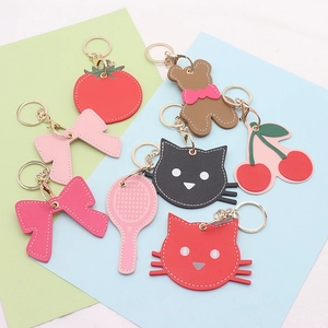 Flat lay of colorful PU leather cartoon keychains featuring fruit and cute shaped designs