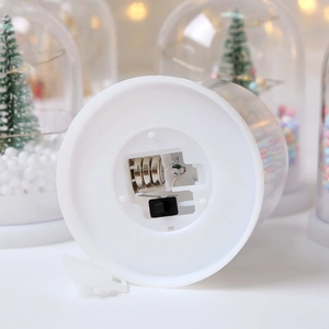Detail view of the Christmas glass dome lamp base with battery compartment and switch