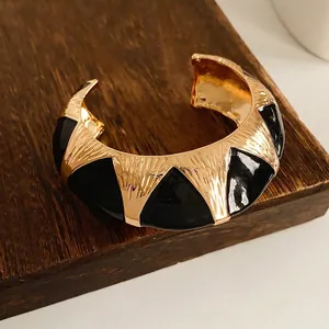 Vintage gold open bangle with black enamel geometric patterns and wave texture