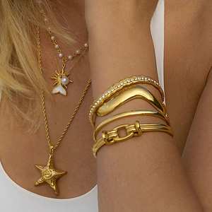 Collane con ciondolo a stella marina dorata e bracciali a strati su una modella