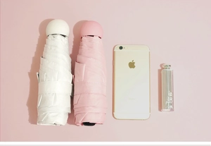Mini capsule umbrella size comparison with phone and lipstick for ultra-portable view