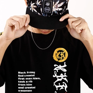 Close-up of black cotton T-shirt featuring white text print and yellow circular graphic