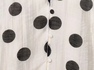 Detailed close-up of polka dot fabric with textured ribbing and matching buttons