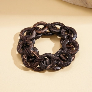 Dettaglio delle perline in guscio di cocco marrone scuro su bracciale etnico multistrato