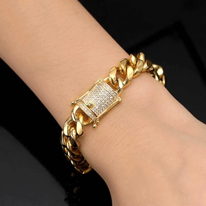 Men's 12mm gold-plated Cuban link bracelet with iced-out rhinestone buckle on wrist
