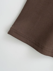 Gros plan sur un tricot côtelé marron avec coutures à double aiguille et texture