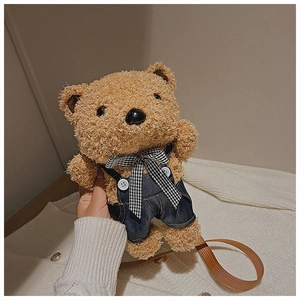 Close-up of a cute plush brown bear shoulder bag wearing denim overalls and a bow tie