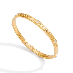 Minimalist 18K gold stainless steel hammered bangle with white crystals on white background