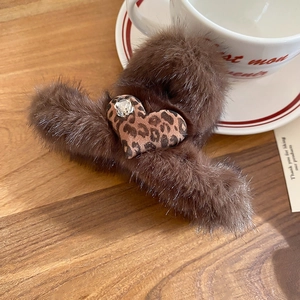 Detail of plush brown claw clip with leopard print heart and sparkling rhinestone