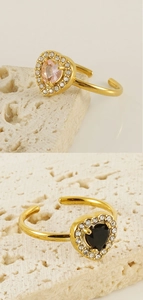 Detail of adjustable double-layered gold rings with pink and black heart-shaped zircons
