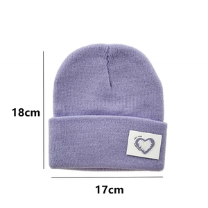 Detail view of purple knit beanie with heart patch showing 18cm height and 17cm width