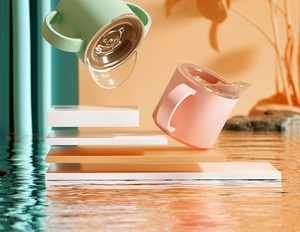 Close-up of pink and green toddler straw cups with handles floating on water surface