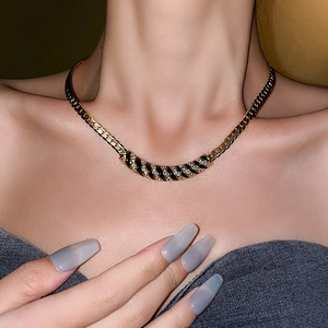 Dettaglio della collana vintage placcata oro con smalto nero e diamanti su una modella