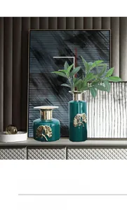Detail of luxury ceramic emerald green vases with golden ginkgo leaf relief set