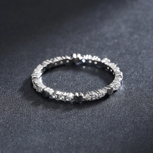 S925 sterling silver heart ring with sparkling round stones on a dark textured surface