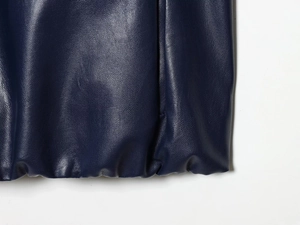 Close-up of deep blue lychee grain faux leather texture on mini skirt hemline