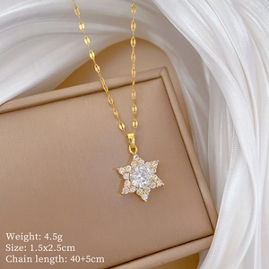 Close-up of golden snowflake pendant with micro-set zircons on elegant silk background