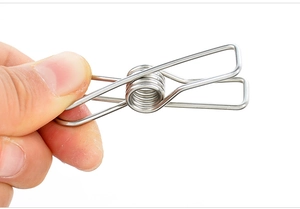 Macro shot of durable stainless steel spring clip held by hand for multi-purpose use