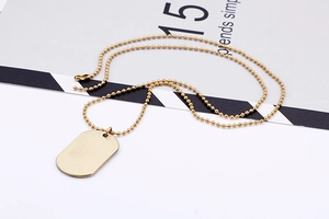 Detail eines polierten goldfarbenen Militär-Erkennungsmarken-Anhänger mit Kugelkette