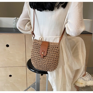Detail of hand-woven paper rope crossbody bag with premium brown leather strap and flap