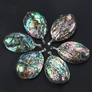 Natural New Zealand abalone shell pendants with metal clasps set on black background
