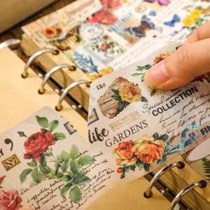 Macro detail of hand peeling vintage floral washi tape with rose and bee patterns
