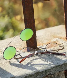 Macro detail of retro steampunk sunglasses with flip-up green mirrored lenses and bronze metal frame