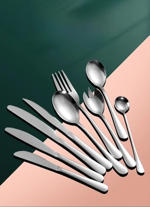 Polished stainless steel cutlery set with assorted knives, forks, and spoons macro detail