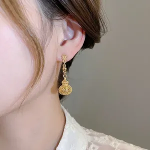 French court style gold-plated hollow lantern drop earrings worn by a model