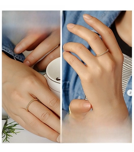 Detail shot of a minimalist gold twisted rope ring showing the elegant metallic texture