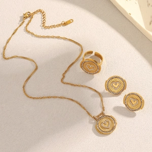 Détail à plat d'un ensemble de bijoux plaqués or 18 carats avec cœurs en zircon sur beige