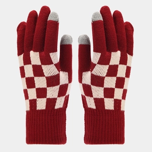 Détail de gants en maille à damier rouge et blanc avec bouts tactiles gris et poignets côtelés