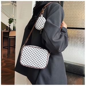 Detail of white patterned crossbody bag set with small round coin purse on shoulder strap