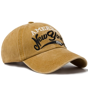 Vintage washed yellow cotton baseball cap with New York 1985 embroidery on white background