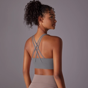 Dettaglio del reggiseno sportivo grigio con spalline incrociate e tessuto elastico