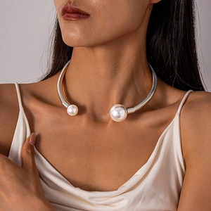 Detailed view of a silver metallic collar necklace featuring two white faux pearls
