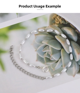 Detail of beaded necklace with white oval pearls and stainless steel extension chain