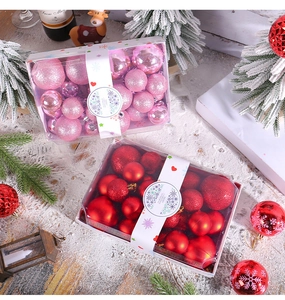 Detailed set of pink and red Christmas balls in gift boxes on snowy festive surface