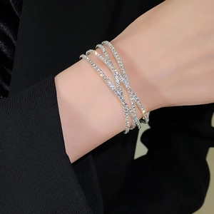 Detail van een sprankelende zilveren meerlaagse armband met ingelegde zirkoon