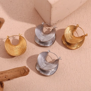 Detail of 18K gold and silver J-shaped crescent earrings with spiral texture on stone base