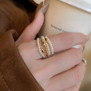 Close-up of multi-layer gold plated ring with pearls worn in a winter fashion setting