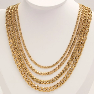 Golden stainless steel Cuban link necklaces in five widths on a white neck display stand