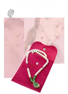 Velvet jewelry pouch with pearl necklace and green pendant featuring gold relief details