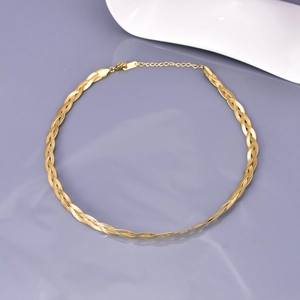 Close-up of triple-layered gold snake chain necklace with ring clasp and extension
